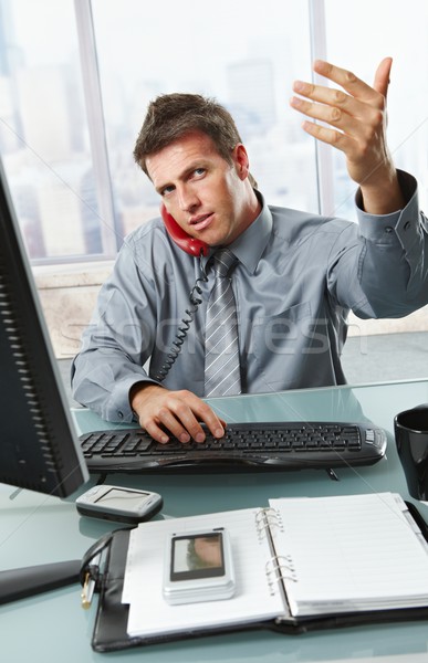 Businessman on call waving working in office Stock photo © nyul