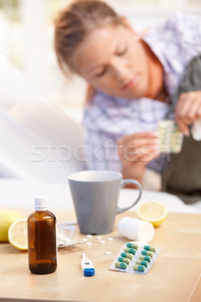Stock photo: Vitamins medicines for flu woman in background