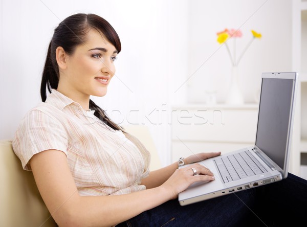 Kadın dizüstü bilgisayar kullanıyorsanız bilgisayar oturma kanepe Stok fotoğraf © nyul