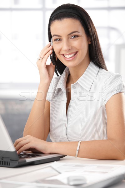 Stockfoto: Vrolijk · kantoor · assistent · met · behulp · van · laptop · computer · mobiele · telefoon