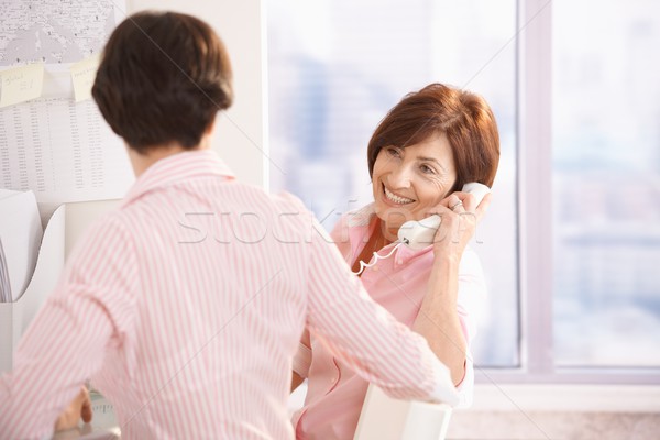 Senior woman on phone call, sitting with coworker Stock photo © nyul