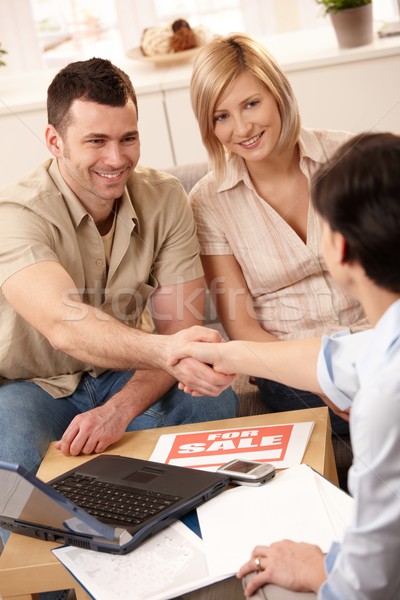 Ingatlanügynök készít üzlet kezet fog fiatalember mosolyog Stock fotó © nyul