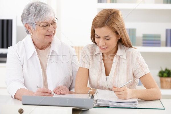 Stock photo: Mother and adult daughter doing paperwork 