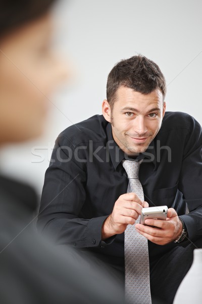 üzletember palmtop fiatal ül kanapé iroda Stock fotó © nyul