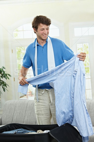 Verpackung Geschäftsreise junger Mann halten blau Shirt Stock foto © nyul