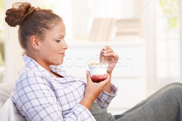 Attractive young woman eating yoghurt in bed Stock photo © nyul