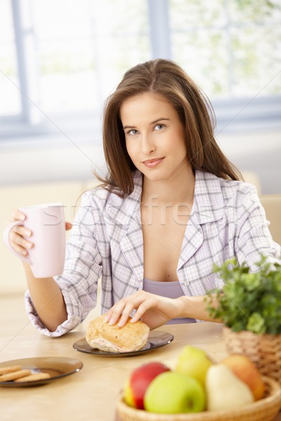 Glimlachende vrouw eten ontbijt keuken thee rollen Stockfoto © nyul