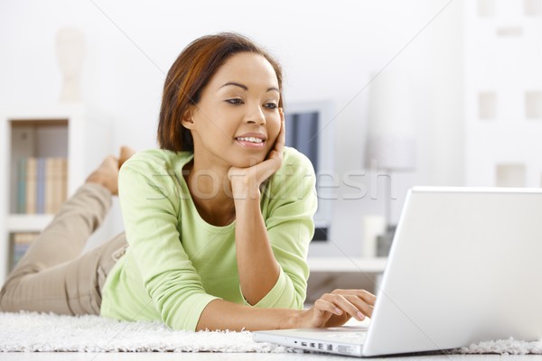 Pretty ethnic girl using laptop at home Stock photo © nyul