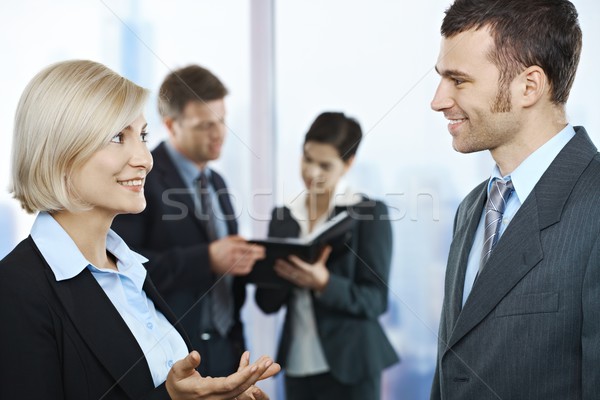 Stock foto: Geschäftsleute · sprechen · stehen · Büro · lächelnd · andere