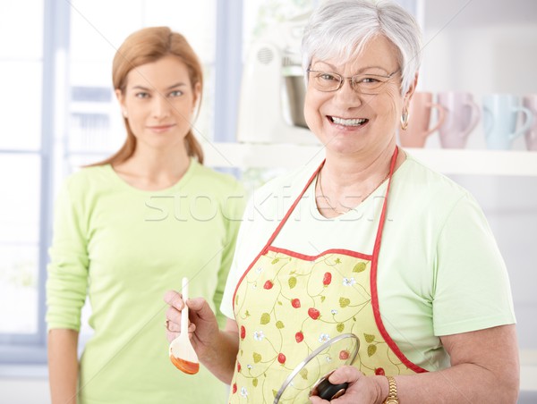 Cheerful senior mother cooking in kitchen Stock photo © nyul
