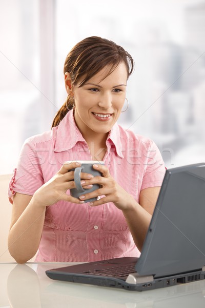 Irodai dolgozó iszik tea asztal néz laptop Stock fotó © nyul