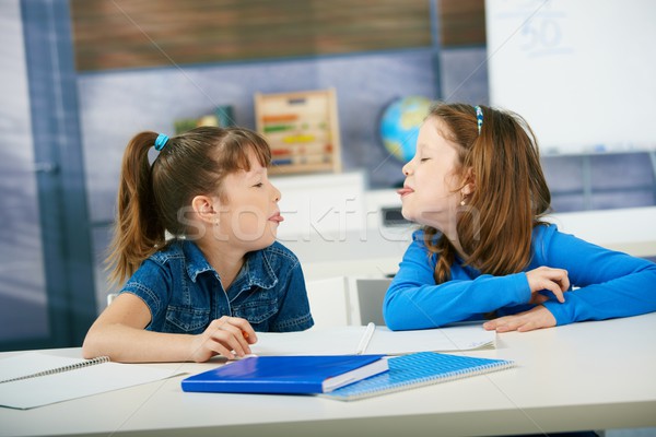 Stock photo: Children sticking tongue in classroom