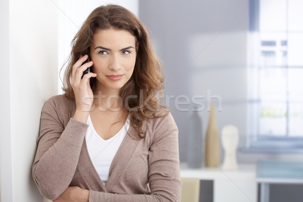 Young woman talking on mobile in living room Stock photo © nyul