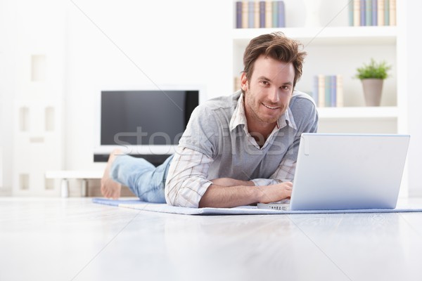 Handsome man laying on floor at home smiling Stock photo © nyul