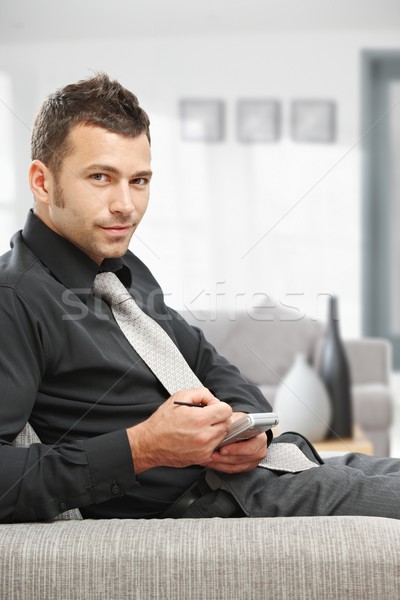 üzletember palmtop fiatal ül kanapé iroda Stock fotó © nyul