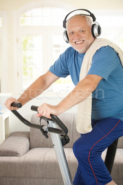 Sporty senior listening to music while exercising Stock photo © nyul