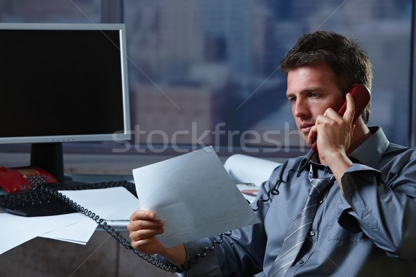 Businessman on phone checking document Stock photo © nyul