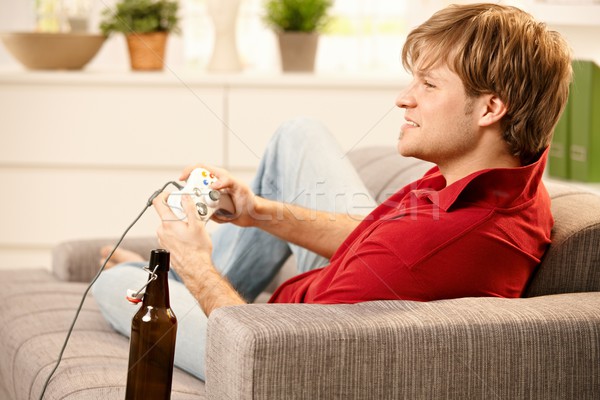 Hombre jugando juego joven sesión sofá Foto stock © nyul