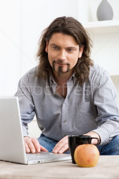 Om folosind laptop calculator ocazional acasă zâmbitor Imagine de stoc © nyul