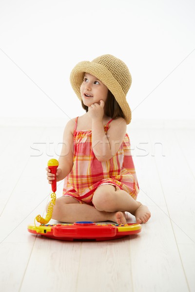 Stock photo: Little girl playing with toy instrument