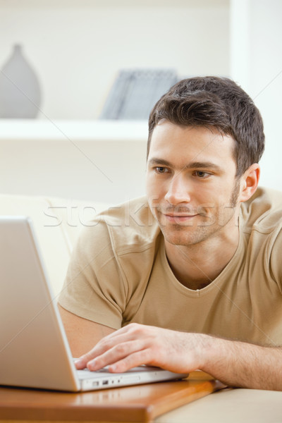 Adam dizüstü bilgisayar kullanıyorsanız ev mutlu genç Stok fotoğraf © nyul