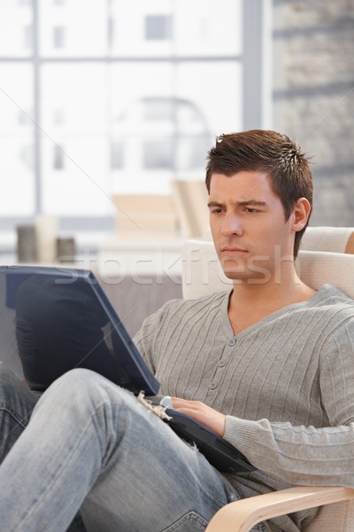 Handsome man concentrating on laptop screen Stock photo © nyul