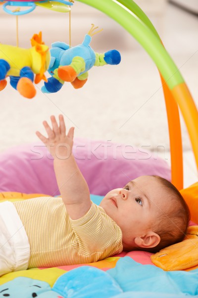 Stock photo: Baby reaching for toy 