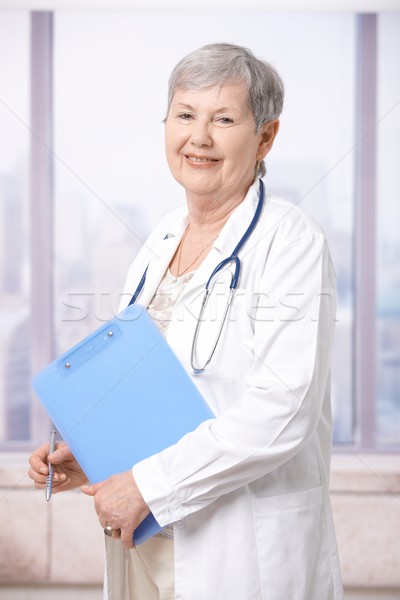 Foto stock: Senior · médico · bloco · de · notas · retrato · em · pé