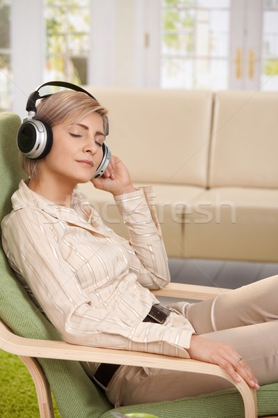 Mujer escuchar música casa relajante sillón Foto stock © nyul