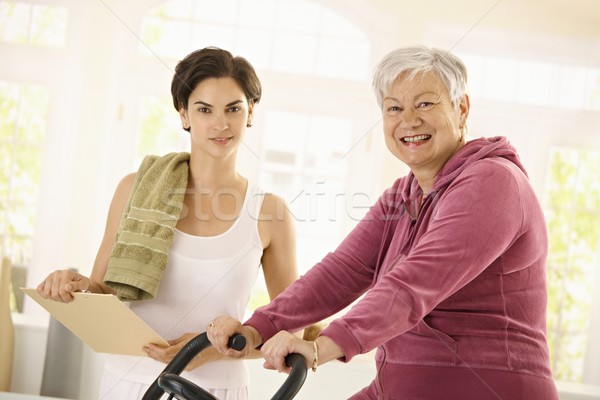 Stock photo: Healthy elderly woman on exercise bike