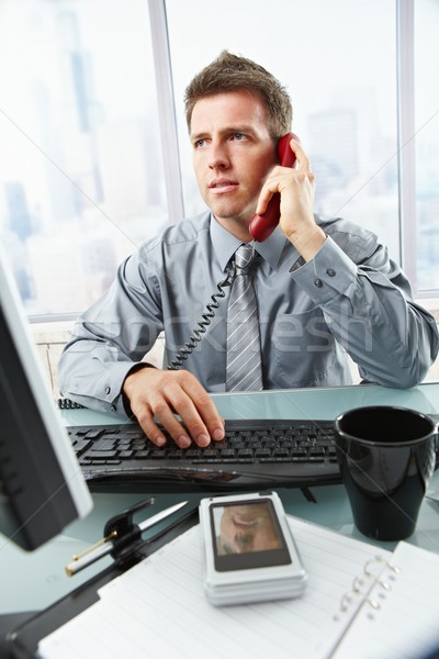 Businessman talking on landline phone in office Stock photo © nyul