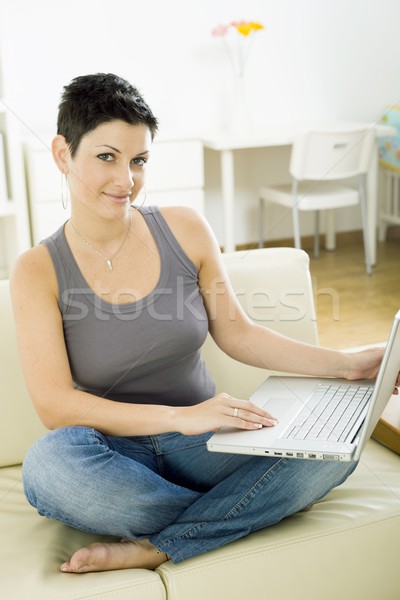 Genç kadın dizüstü bilgisayar oturma kanepe ev çalışma Stok fotoğraf © nyul
