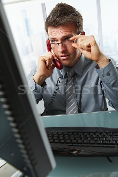 Businessman talking on landline phone in office Stock photo © nyul