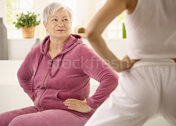 Elderly woman looking at personal trainer Stock photo © nyul