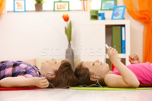 Stockfoto: Schoolmeisjes · luisteren · naar · muziek · hoofdtelefoon · mp3-speler · samen · glimlachend