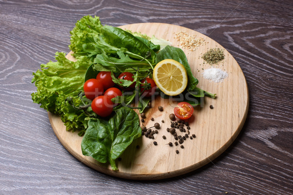 Stock photo: Lettuce, rucola, tomatoes on wooden chopping board