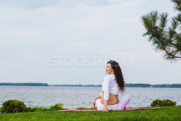 Stock photo: Pregnant woman is practicing yoga beside river