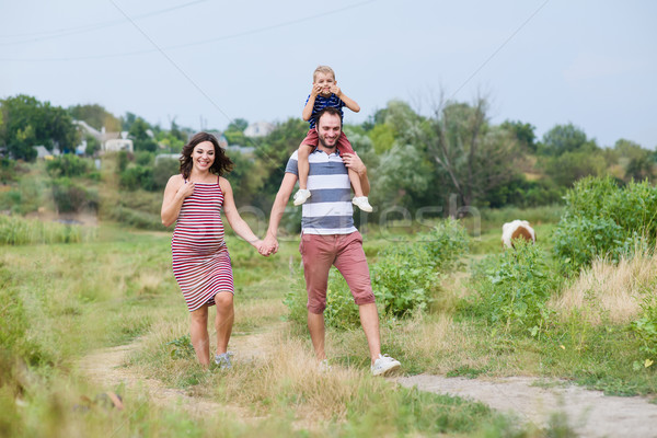 Feliz grávida família risonho andar Foto stock © O_Lypa