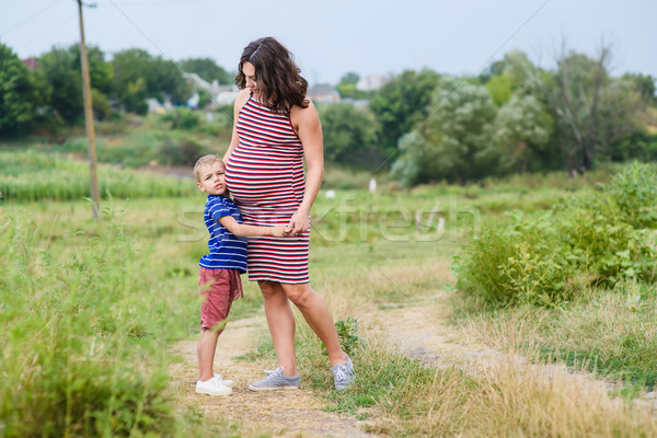 Child hugging his pregnant mother Stock photo © O_Lypa