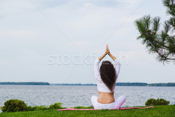 Stock photo: Pregnant woman is practicing yoga beside river