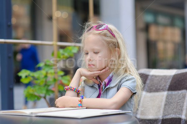Pretty child reading menu in the cafe Stock photo © O_Lypa