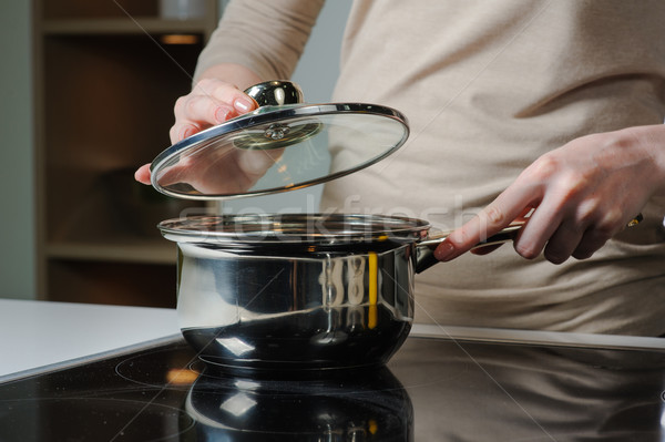 Person removing lid from cooking pot Stock photo © O_Lypa