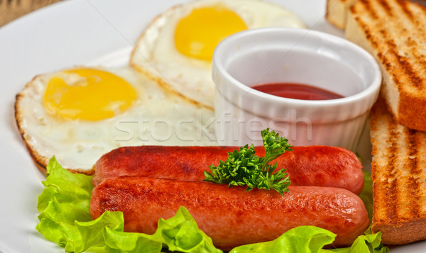 Fried eggs with sausages Stock photo © olira
