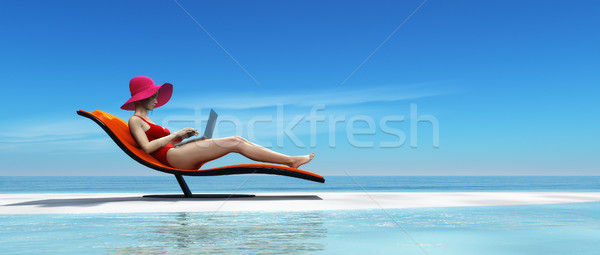 Donna costume da bagno utilizzando il computer portatile seduta lettino spiaggia tropicale Foto d'archivio © orla