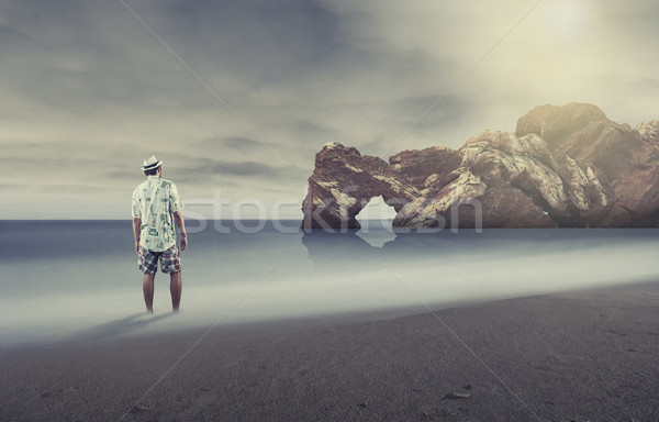 молодым человеком ног воды глядя морем песок Сток-фото © orla