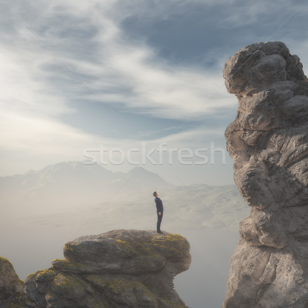 Young businessman standing on edge of rock mountain  Stock photo © orla