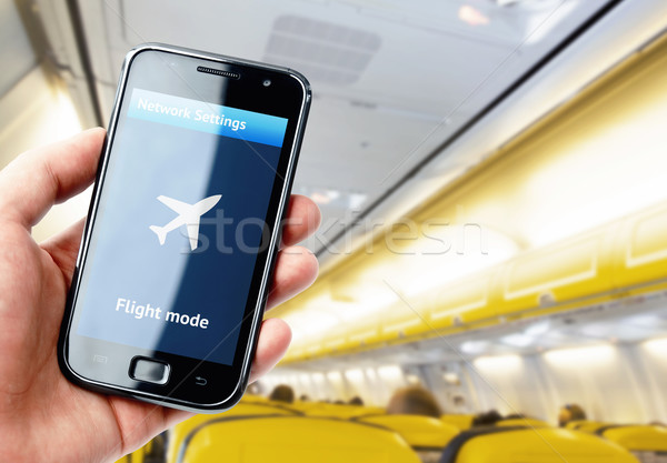 Hand holding smartphone inside the plane Stock photo © pab_map