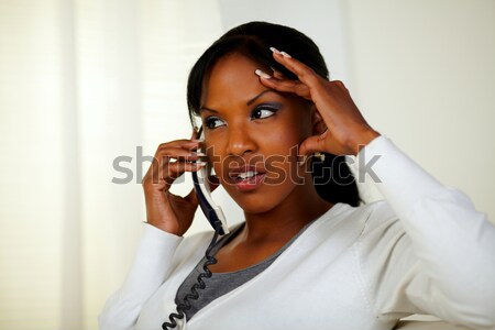 Stock photo: Pensive young woman conversing on cellphone