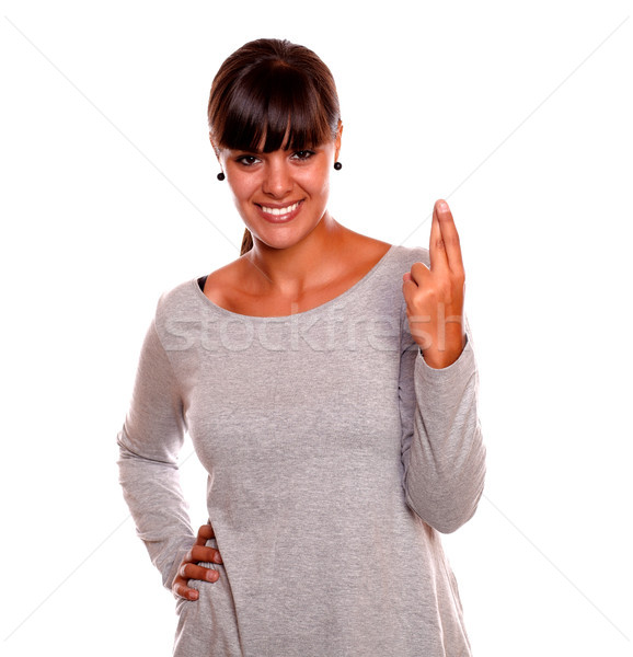 Stock photo: Smiling young woman crossing her fingers for luck