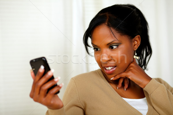 Stock fotó: Töprengő · afroamerikai · nő · mobiltelefon · portré · otthon · bent